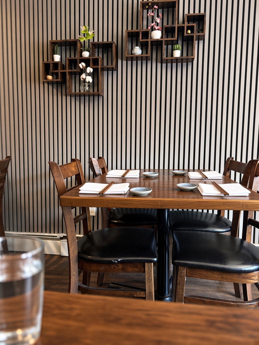 Wooden dining tables set with chopsticks and ceramic dishes